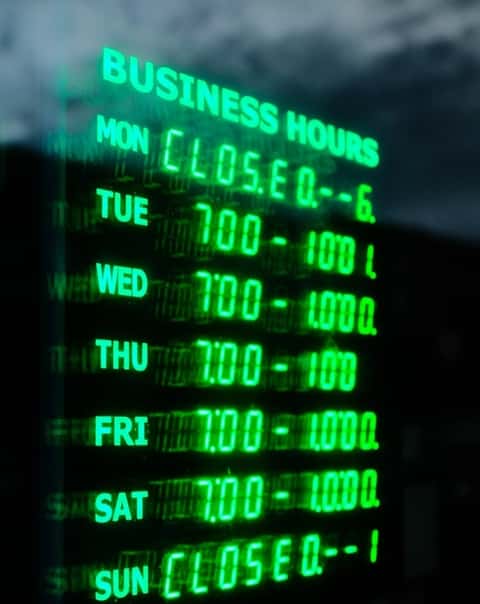 weekly business hours opening times displayed in shop window front