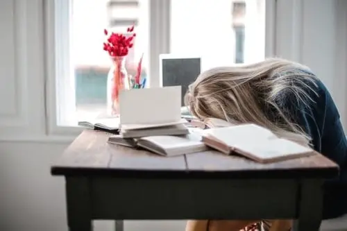 tired woman with head on desk 
