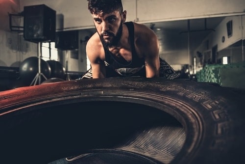 man flipping tire in gym