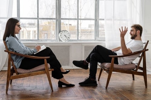 psychologist talking to a man in a chair 